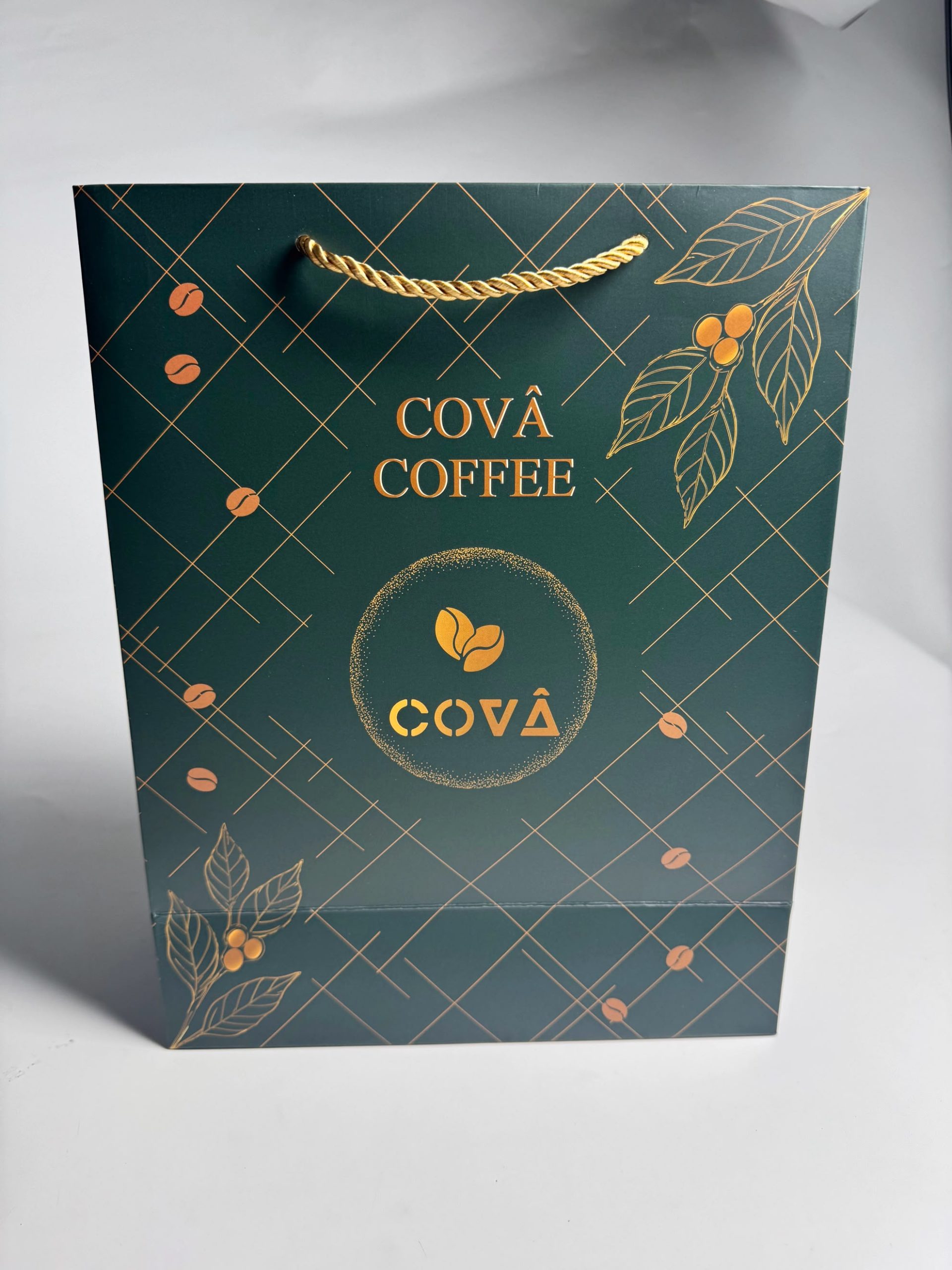 Covâ Coffee emerald green carrier bag with gold rope handles